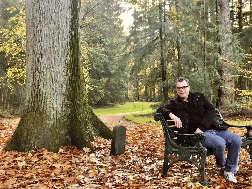 Rob de Kerf op een bank in het bos